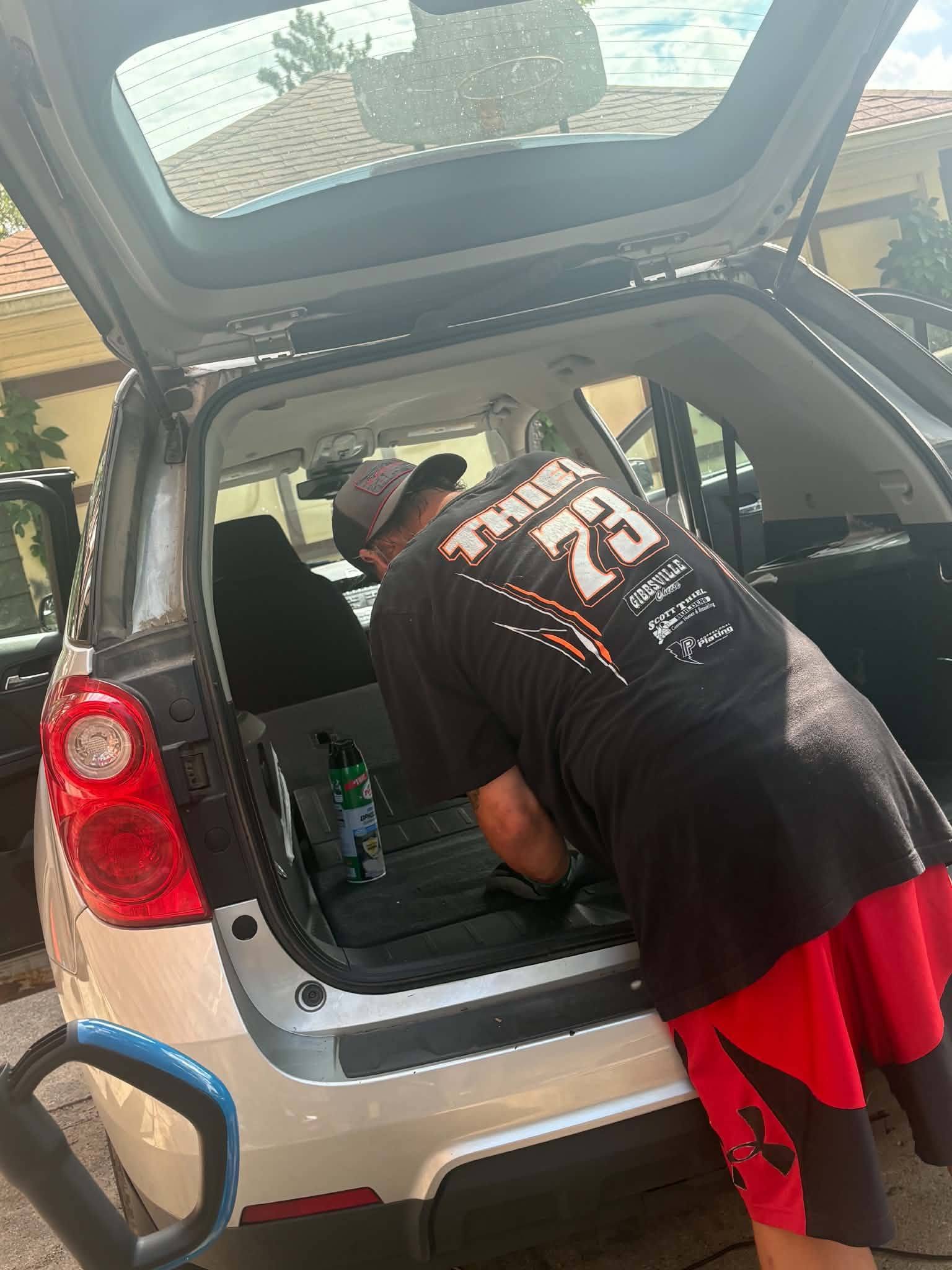 Mobile detailer cleaning a vehicle trunk